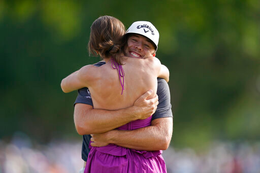 Sam Burns, right, hugs his wife Caroline Burns after winning the Charles Schwab Challenge golf tournament at the Colonial Country Club in Fort Worth, Texas, Sunday, May 29, 2022. (AP Photo/LM Otero)