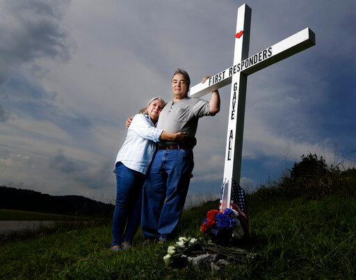 FILE - In this Aug. 6, 2019, photo, Ansol and Janie Clark pose at a memorial Ansol Clark constructed near the Kingston Fossil Plant in Kingston, Tenn. The Tennessee Valley Authority was responsible for a massive coal ash spill at the plant in 2008 that covered a community and fouled rivers. The couple says the memorial is for the workers who have come down with illnesses, some fatal, including cancers of the lung, brain, blood and skin and chronic obstructive pulmonary disease. Ansol Clark who drove a fuel truck for four years at the cleanup site, and suffered from a rare blood cancer, has also died now. (AP Photo/Mark Humphrey, File)