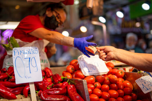 FILE - A customer pays for vegetables at the Maravillas market in Madrid, Thursday, May 12, 2022. Inflation hit a new record of 8.1% for the 19 countries that use the euro powered by surging energy costs boosted by the Russia-Ukraine war. The latest data Tuesday, May 31, 2022 from the European Union's statistics agency Eurostat showed that annual inflation in May surpassed the previous record of 7.4% reached in the previous two months.  (AP Photo/Manu Fernandez, File)
