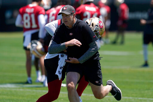 San Francisco 49ers quarterbacks coach Brian Griese, foreground, runs a drill with quarterback Trey Lance at the NFL football team's practice facility in Santa Clara, Calif., Tuesday, May 24, 2022. Griese, an 11-year quarterback in the NFL, left the cushy work of a broadcaster to get back into the grind of the NFL as the 49ers quarterbacks coach tasked with developing Lance into a star. (AP Photo/Jeff Chiu)