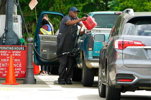 A customer pumps gas at this Madison, Miss., Sam's Club, after filling up a gasoline container, Tuesday, May 24, 2022. Wholesale retail chains stores like Costco and Sam's Club tend to price their gas and diesel competitively against one another while major gas chain prices are usually higher. (AP Photo/Rogelio V. Solis)