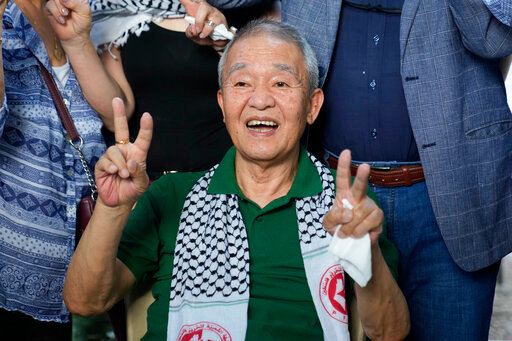 Kozo Okamoto, 74, a member of the Japanese Red Army guerrilla group, who served 12 years in an Israeli prison for his part in the May 30, 1972 attack on Tel Aviv airport that killed 24 people, gives the victory sign to supporters as he arrives at a Palestinian cemetery to visit a memorial for four Japanese who died in support of Palestinians, in Beirut, Lebanon, Monday, May 30, 2022. The Popular front for the Liberation of Palestine, a radical Palestinian faction commemorated in Beirut Monday the 50th anniversary of an attack on Tel Aviv's airport in Israel that was carried out by members the Japanese Red Army guerrilla group. (AP Photo/Hassan Ammar)