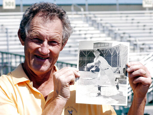 Former major league pitcher Jim Kaat poses with a photo of himself at age 19 before a spring training baseball game between the Houston Astros and the Florida Marlins  in Jupiter, Fla., March 22, 2004. Minnesota Twins broadcaster Kaat referred to New York Yankees left-hander Nestor Cortes by an offensive nickname during a broadcast Thursday, June 2, 2022, the second offensive remark in the past year by the 83-year-old Hall of Fame pitcher while calling a game. (AP Photo/James A. Finley, File)