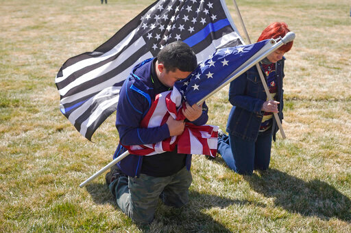 FILE - Marius Annandale kneels while praying during a Second Amendment gun rights rally at the Utah State Capitol Saturday, March 27, 2021, in Salt Lake City. After a gunman killed 19 children and two teachers at an elementary school in Uvalde, Texas, on May 24, 2022, several pastors and rabbis around the country have challenged their conservative counterparts with this question: Are you pro-life if you are pro-guns? (AP Photo/Rick Bowmer, File)