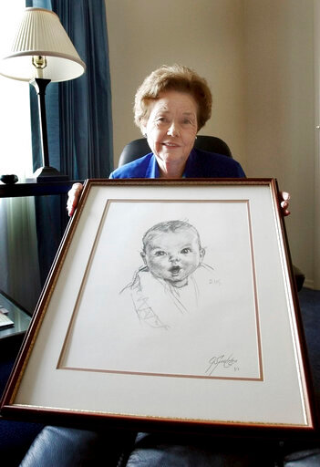 RETRANSMISSION TO CORRECT NAME - FILE - Ann Turner Cook, poses at her Tampa, Fla., home Wednesday afternoon Feb. 4, 2004, with a copy of her photo that is used on all Gerber baby food products. Ann Turner Cook, whose cherubic baby face was known the world over as the original Gerber baby, has died. She was 95. Gerber announced Cook's passing in an Instagram post on Friday, June 3, 2022. (AP Photo/Chris O'Meara, File)