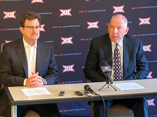 Big 12 commissioner Bob Bowlsby, right, and Texas Tech president Lawrence Schovanec, chairman of the Big 12 board of directors, talk with media at the end of the conference's annual spring meetings, Friday, June 3, 2022, in Irving, Texas. The Big 12 is distributing a record $426 million to its 10 schools for the 2021-22 academic year, and expects to have a new commissioner in place by mid-July. Bowlsby is retiring. (AP Photo/Stephen Hawkins).