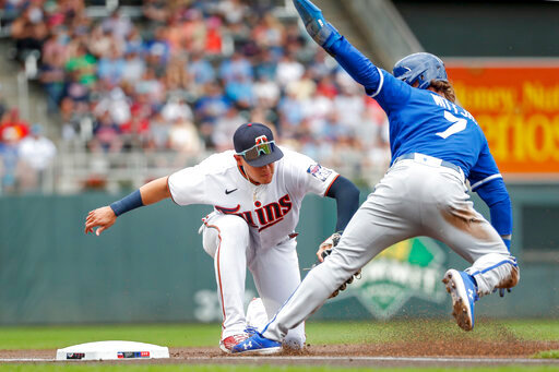 Minnesota Twins third baseman Gio Urshela, left, tags out Kansas City Royals' Bobby Witt on a fielder's choice hit by Salvador Perez in the first inning of a baseball game Saturday, May 28, 2022, in Minneapolis. (AP Photo/Bruce Kluckhohn)