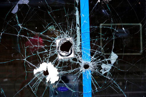 ADDS CONTEXT AND DETAIL THAT THESE BULLET HOLES ARE FROM A PRIOR SHOOTING - Bullet holes from a prior shooting are still present in a storefront window at the scene of a fatal overnight shooting on South Street in Philadelphia, Sunday, June 5, 2022. (AP Photo/Michael Perez)