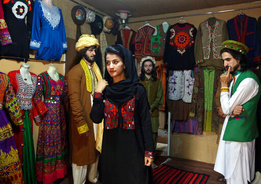 FILE - Ajmal Haqiqi, right, watches as Mahal Wak, center, practices modeling, in Kabul, Afghanistan, Aug. 3, 2017. The Taliban have detained a famous Afghan fashion model along with three colleagues, including Haqiqi, accusing them of disrespecting Islam and the Holy Quran. Haqiqi &mdash; known among Afghans for his fashion shows, You Tube clips, and modeling events &mdash; appeared handcuffed in videos posted to Twitter on Tuesday, June 7, 2022, by the Taliban&rsquo;s General Directorate of Intelligence, DCI. (AP Photo/Rahmat Gul, File)