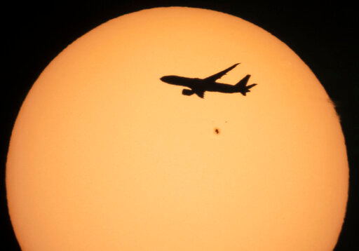 A cargo Boeing 777 of China Southern Airlines flying from Amsterdam to Shanghai is silhouetted against the sun as it flies over the village of Podolye, 70 kilometers (43 miles) east of St. Petersburg, Russia, on Oct. 11, 2021. An industry group representing most major airlines criticized the European Union's Parliament on Thursday, June 9, 2022 for seeking to expand its emissions trading system to all departing flights. (AP Photo/Dmitri Lovetsky, File)