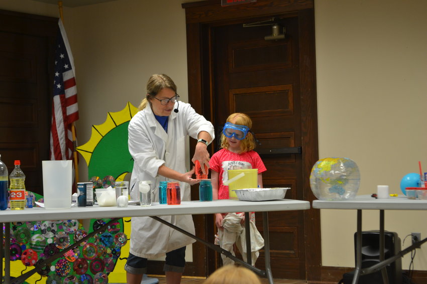 Emily Harris, right, assists Jean Harris, a.k.a. The Nutty Professor, with an experiment about the density of water at the Pittsburg Public Library on Thursday.
