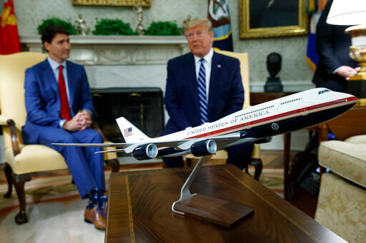FILE - A model of the new Air Force One design sits on a table during a meeting between President Donald Trump and Canadian Prime Minister Justin Trudeau in the Oval Office of the White House, June 20, 2019, in Washington. President Joe Biden's administration has scrapped former President Trump's red, white and blue design for the new generation of presidential aircraft after an Air Force review suggested it would raise costs and delay the delivery of the new jets. (AP Photo/Evan Vucci, File)