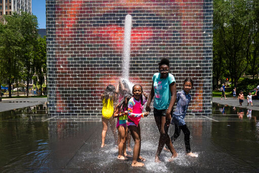 Children play in the Crown Fountain on Michigan Avenue, Tuesday afternoon, June 14, 2022, in Chicago. Much of the Midwest and a swath of the South braced for a potentially dangerous and deadly heat wave on Tuesday, with temperatures that could reach record highs in some places and combine with humidity to make it feel like it&rsquo;s 100 degrees or hotter in spots. (Ashlee Rezin/Chicago Sun-Times via AP)