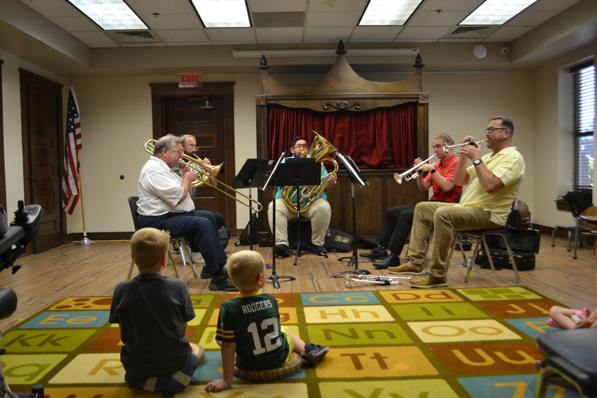 As a continuation of the Pittsburg Festival of the Arts music performance series, the Pittsburg Brass Quintet plays at the Pittsburg Public Library on Tuesday. From left, Robert Kehle, Cooper Neil, Johnathan De Soto Jr., Tyler Fries, and Todd Hastings perform &ldquo;What a Wonderful World&rdquo; and other songs for an audience of over 20 people.