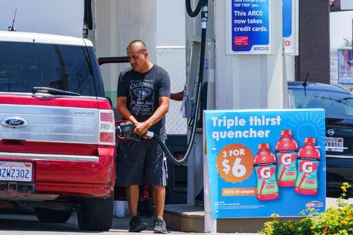 FILE - A motorist pumps gasoline at an ARCO gas station in Los Angeles, Sunday, June 12, 2022. Soaring gasoline prices have left many consumers with no choice but to cut spending on non-essentials, but it might be coming full circle by stopping some drivers from filling up their tanks. (AP Photo/Damian Dovarganes, File)