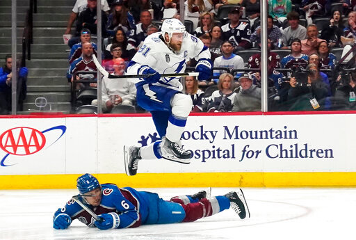 Tampa Bay Lightning center Steven Stamkos (91) jumps over Colorado Avalanche defenseman Erik Johnson (6) during the second period of Game 1 of the NHL hockey Stanley Cup Final on Wednesday, June 15, 2022, in Denver. (AP Photo/John Locher)