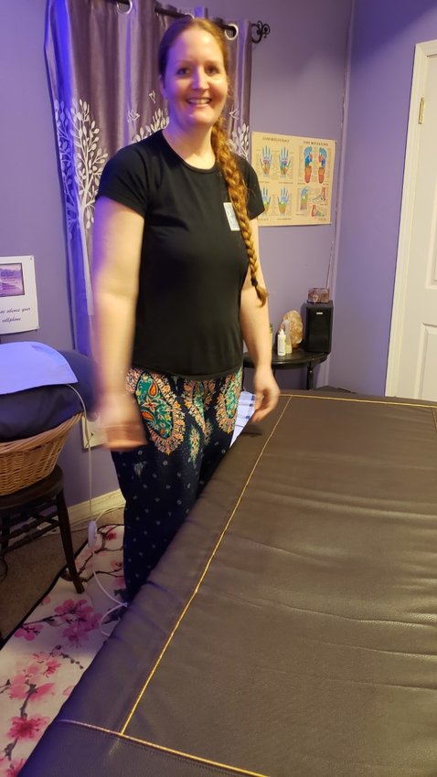 Kelli Passeri prepares her vibroacoustic massage mat for her next client. The mat uses vibration to enhance the relaxation and pain relieving aspects of massage therapy.