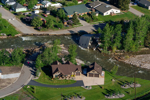 FILE - A house sits in Rock Creek after floodwaters washed away a road and a bridge in Red Lodge, Mont., in Red Lodge, Mont., June 16, 2022. (AP Photo/David Goldman, File)