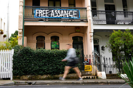A pedestrian walks past a house with a sign in support of WikiLeaks founder Julian Assange in Sydney, Australia, Monday, June 20, 2022. Australian Prime Minister Anthony Albanese on Monday rejected calls for him to publicly demand the United States drop its prosecution of WikiLeaks founder and Australian citizen Julian Assange.(AP Photo/Mark Baker)