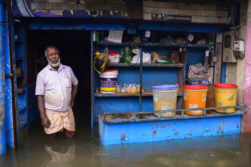 A man stands at the doorway of his flooded shop in Sylhet, Bangladesh, Monday, June 20, 2022. Floods in Bangladesh continued to wreak havoc Monday with authorities struggling to ferry drinking water and  dry food to flood shelters across the country&rsquo;s vast northern and northeastern regions. (AP Photo/Mahmud Hossain Opu)