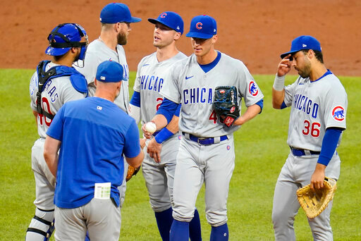 Chicago Cubs starting pitcher Caleb Kilian, center, hands the ball to manager David Ross during a pitching change in the third inning of a baseball game against the Pittsburgh Pirates in Pittsburgh, Monday, June 20, 2022. (AP Photo/Gene J. Puskar)