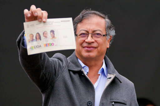 Gustavo Petro, presidential candidate with the Historical Pact coalition, shows his ballot before voting in a presidential runoff in Bogota, Colombia, Sunday, June 19, 2022. (AP Photo/Fernando Vergara)