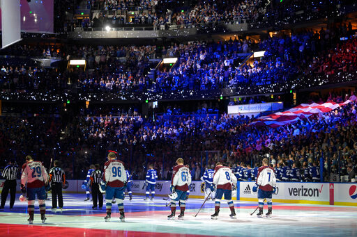 The Colorado Avalanche and the Tampa Bay Lightning stand during the national anthem before the first period of Game 4 of the NHL hockey Stanley Cup Finals on Wednesday, June 22, 2022, in Tampa, Fla. (AP Photo/Phelan Ebenhack)