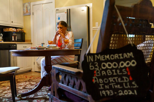 Tanya Britton prays before lunch as a sign memorializing babies aborted in the United States hangs on a chair in her kitchen in Tupelo, Miss., Tuesday, May 24, 2022. &quot;Whatever I do, let it be for the end of abortion,&quot; 70-year-old Britton prays. &quot;Let it be that one child be saved today. Let it be that Roe v. Wade be overturned.&quot; (AP Photo/David Goldman)