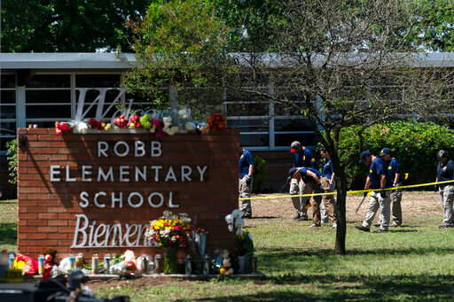 FILE - Investigators search for evidences outside Robb Elementary School in Uvalde, Texas, May 25, 2022, after an 18-year-old gunman killed 19 students and two teachers. The district&rsquo;s superintendent said Wednesday, June 22, that Chief Pete Arredondo, the Uvalde school district&rsquo;s police chief,  has been put on leave following allegations that he erred in his response to the mass shooting.  (AP Photo/Jae C. Hong, File)