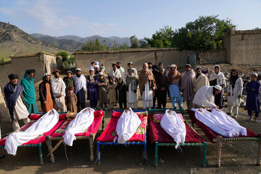 Afghans stand by the bodies of relatives killed in an earthquake in Gayan village, in Paktika province, Afghanistan, Thursday, June 23, 2022. A powerful earthquake struck a rugged, mountainous region of eastern Afghanistan early Wednesday, flattening stone and mud-brick homes in the country's deadliest quake in two decades, the state-run news agency reported. (AP Photo/Ebrahim Nooroozi)