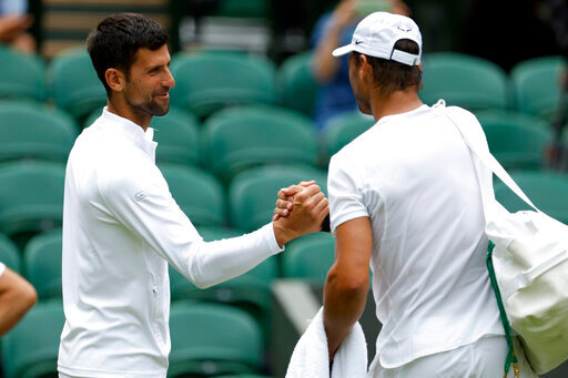 Spain's Rafael Nadal, right, greets Serbia's Novak Djokovic during a practice session on on Center Court ahead of the 2022 Wimbledon Championship at the All England Lawn Tennis and Croquet Club, in London, Thursday, June 23, 2022. (Steven Paston/PA via AP)