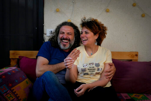 Mazen Jaber and Dona-Maria Nammour, who had a civil marriage in Cyprus earlier this year, laugh as they speak during an interview with The Associated Press at their home in Beirut, Lebanon, Friday, June 3, 2022. In Lebanon, the question of civil marriage is a contentious issue mired in fierce religious and political debates. (AP Photo/Bilal Hussein)