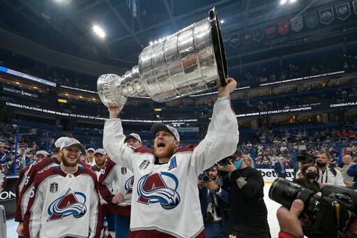 Colorado Avalanche center Nathan MacKinnon lifts the Stanley Cup after the team defeated the Tampa Bay Lightning in Game 6 of the NHL hockey Stanley Cup Finals on Sunday, June 26, 2022, in Tampa, Fla. (AP Photo/Phelan Ebenhack)