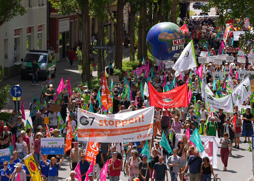 FILE - Climate activists and others hold banners and signs as they march during a demonstration ahead of a G-7 meeting in Munich, Germany, June 25, 2022. At this year's G-7 summit, Germany will push its plan for countries to join together in a &lsquo;climate club' to tackle global warming.  (AP Photo/Matthias Schrader, File)