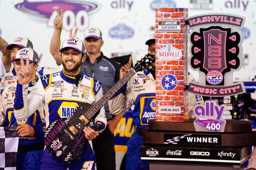 Chase Elliott poses with his guitar and trophy after winning a NASCAR Cup Series auto race Sunday, June 26, 2022, in Lebanon, Tenn. (AP Photo/Mark Humphrey)