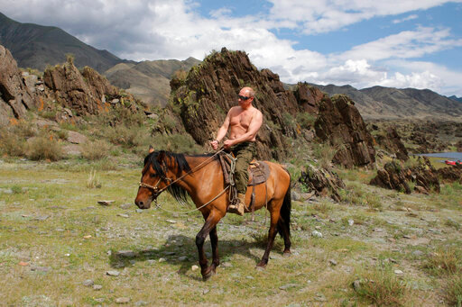 FILE - Then Russian Prime Minister Vladimir Putin rides a horse while traveling in the mountains of the Siberian Tyva region (also referred to as Tuva), Russia, Aug. 3, 2009. Putin has shot back at Western leaders who mocked his athletic exploits, saying they would look &ldquo;disgusting&rdquo; if they tried to emulate his bare-torso appearances. Putin made the comment during a visit to Turkmenistan early Thursday, June 30, 2022 when asked about Western leaders joking about him at the G-7 summit. (Alexei Druzhinin/Pool Photo via AP, file)
