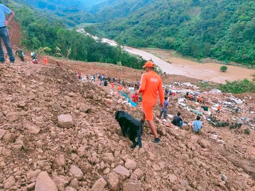 This photograph provided by India's National Disaster Response Force (NDRF) shows NDRF personnel and others trying to rescue those buried under the debris after a mudslide in Noney, northeastern Manipur state, India, Thursday, June 30, 2022. (National Disaster Reponse Force via AP)