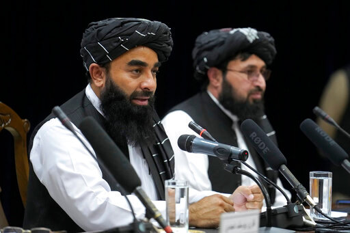 Zabiullah Mujahid, left, the spokesman for the Taliban government, speaks during a press conference in Kabul, Afghanistan, Thursday, June 30, 2022. Afghanistan's Taliban rulers held a gathering Thursday of some 3,000 Islamic clerics and tribal elders for the first time since seizing power in August, urging them to advise them on running the country. Women were not allowed to attend. (AP Photo/Ebrahim Noroozi)