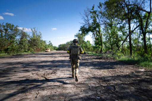 A Ukrainian serviceman changes his position at the frontline near Kharkiv, Ukraine, on Saturday, July 2, 2022. (AP Photo/Evgeniy Maloletka)