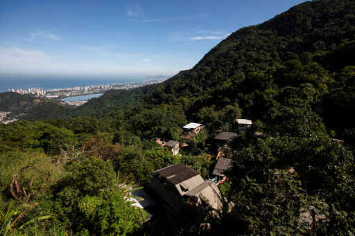 Houses in the Enchanted Valley sustainable community stand on the outskirts of Tijuca National Forest in Rio de Janeiro, Brazil, Monday, June 6, 2022. Electricity arrived in the late 20th century to the low-income Enchanted Valley community, but the utility never connected it to the city&rsquo;s sewage network, so its residents set out to solve the problem on its own by building a biodigester and artificial wetland to process all sewage generated by all of its 40 families. (AP Photo/Bruna Prado)