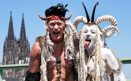 Participants of the Cologne Pride rally pose in front of the Cathedral in Cologne, Germany, Sunday, July 3, 2022. This year's Christopher Street Day (CSD) Gay Parade with thousands of demonstrators for LGBTQ rights is the first after the coronavirus pandemic to be followed by hundreds of thousands of spectators in the streets of Cologne. (AP Photo/Martin Meissner)