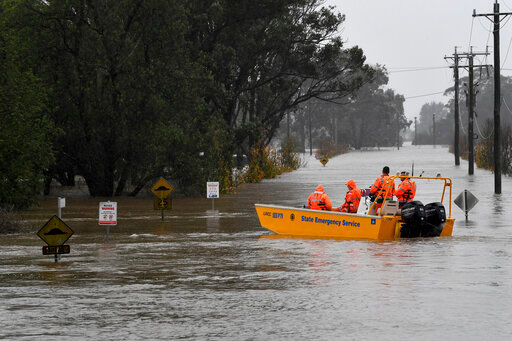 A New South Wales State Emergency Service (SES) crew is seen in a rescue boat as roads are submerged under floodwater from the swollen Hawkesbury River in Windsor, northwest of Sydney, Monday, July 4, 2022. (Bianca De Marchi/AAP Image via AP)