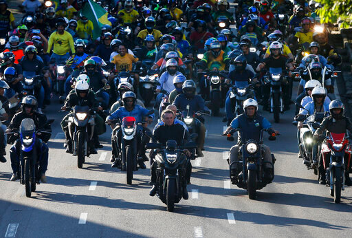 FILE - Brazil's President Jair Bolsonaro, center, leads a motorcycle rally in Manaus, Brazil, June 18, 2022. With the election just three months off, some polls show only one in five women will vote for the tough-talking, pro-gun, motorcycle-riding former Army captain. (AP Photo/Edmar Barros, File)