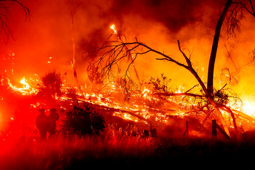 Firefighters battle the Electra Fire in the Rich Gulch community of Calaveras County, Calif., on Monday, July 4, 2022. According to Amador County Sheriff Gary Redman, approximately 100 people sheltered at a Pacific Gas &amp; Electric facility before being evacuated in the evening. (AP Photo/Noah Berger)