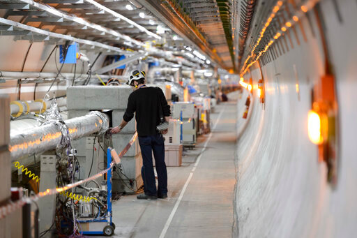 FILE - A technician works in the LHC (Large Hadron Collider) tunnel of the European Organization for Nuclear Research, CERN, during a press visit in Meyrin, near Geneva, Switzerland, Feb. 16, 2016. The physics lab that&rsquo;s home to the world&rsquo;s largest atom smasher announced on Tuesday, July 5, 2022 the observation of three new &ldquo;exotic particles&rdquo; that could provide clues about the force that binds subatomic particles together. The observation of a new type of pentaquark and the first duo of tetraquarks at CERN, the Geneva-area home to the LHC, offers a new angle to assess the so-called &ldquo;strong force&rdquo; that holds together the nuclei of atoms. (Laurent Gillieron/Keystone via AP, file)