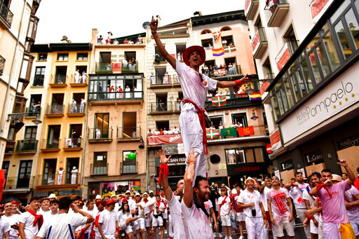Revellers celebrate while waiting for the launch of the 'Chupinazo' rocket, to mark the official opening of the 2022 San Fermin fiestas in Pamplona, Spain, Wednesday, July 6, 2022. The blast of a traditional firework opens Wednesday nine days of uninterrupted partying in Pamplona's famed running-of-the-bulls festival which was suspended for the past two years because of the coronavirus pandemic. (AP Photo/Alvaro Barrientos)