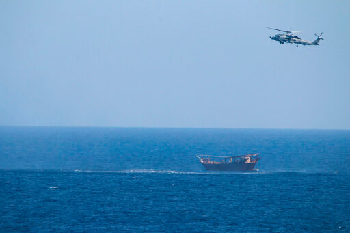 FILE - A U.S. Navy Seahawk helicopter flies over a stateless dhow later found to be carrying a hidden arms shipment in the Arabian Sea, May 6, 2021. The U.S. Navy's Mideast-based 5th Fleet will begin Tuesday, July 5, 2022, to offer rewards for information that could help sailors intercept weapons, drugs and other illicit shipments across the region. The program launches against the backdrop of tensions over Iran&rsquo;s nuclear program and Tehran&rsquo;s arming of Yemen&rsquo;s Houthi rebels. (U.S. Navy via AP, File)