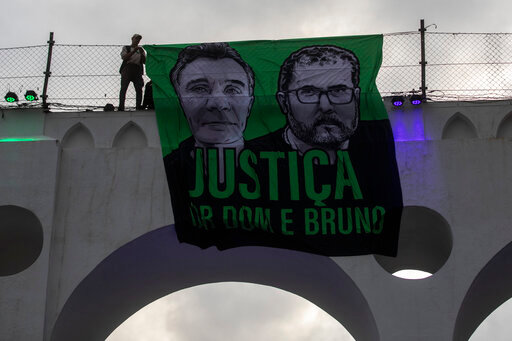 A sign that reads in Portuguese &quot;Justice for Dom and Bruno&quot; and with images of the British journalist Dom Phillips, on the left, and the indigenous specialist Bruno Pereira is displayed on the Arcos da Lapa aqueduct during a protest by environmental groups to ask for justice for their deaths, in Rio de Janeiro, Brazil, Sunday, June 26, 2022. (AP Photo/Bruna Prado)