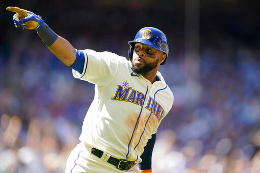 Seattle Mariners' Carlos Santana gestures as he heads to first after hitting a two-run home run against the Toronto Blue Jays during the eighth inning of a baseball game, Sunday, July 10, 2022, in Seattle. Santana had two home runs and the Mariners won 6-5. (AP Photo/Ted S. Warren)