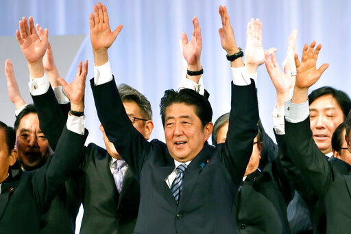 FILE - Japanese Prime Minister Shinzo Abe, center, shouts traditional &quot;Banzai (long life)&quot; cheers with lawmakers and members of his ruling Liberal Democratic (LDP) Party during its annual convention at a hotel in Tokyo on March 5, 2017. Assassinated former Prime Minister Shinzo Abe was perhaps the most divisive leader in recent Japanese history. He was also the longest serving and, by many estimations, the most influential. (AP Photo/Shizuo Kambayashi, File)